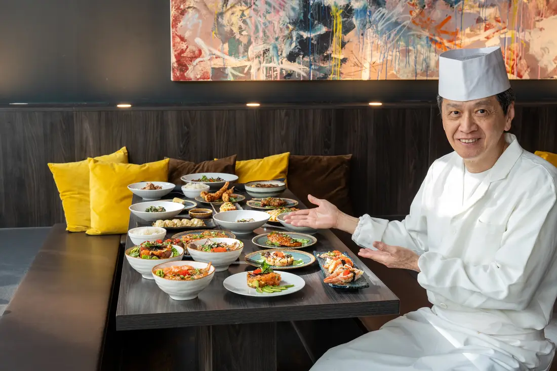 Le maître sushi Robin E.J. Ong devant une table dressée avec sushis, sashimis et bols chez Mikôto Stuttgart