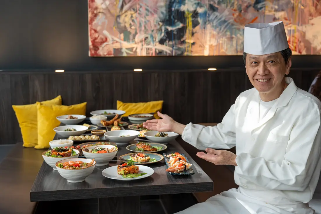 Le maître sushi Robin E.J. Ong devant une table dressée avec sushis, sashimis et bols chez Mikôto Stuttgart