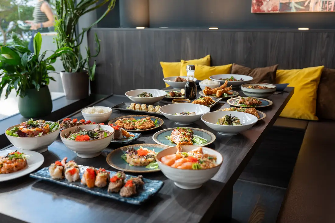 Le maître sushi Robin E.J. Ong devant une table dressée avec sushis, sashimis et bols chez Mikôto Stuttgart